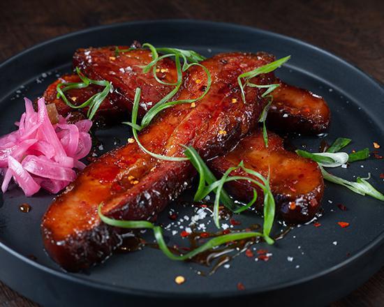 Bacon Candy · Slow-braised bacon, sweet and salty glaze, pickled red onion and red chili flakes.