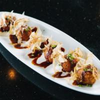 Takoyaki · 6 pieces of chopped octopus and vegetables made in balls marinated with house seasoning.