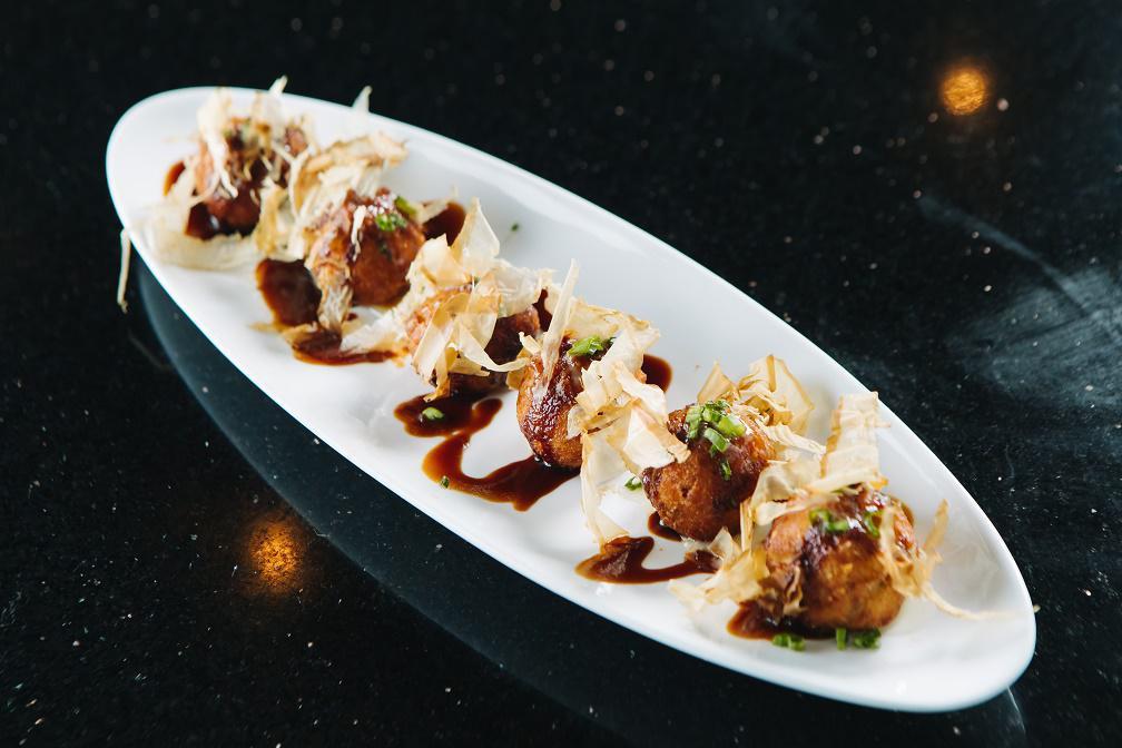 Takoyaki · 6 pieces of chopped octopus and vegetables made in balls marinated with house seasoning.