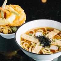 Tempura Udon · Traditional Japanese noodle soup in a pot with chicken, cabbage, egg and shrimp tempura.