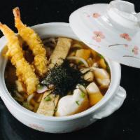 Nakeyaki Udon · Traditional Japanese noodle soup in a pit with chicken, cabbage, egg, and shrimp.