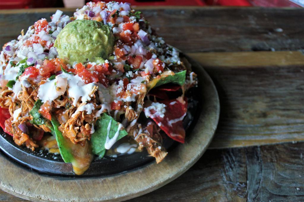 Fiesta Nacho · Tender chicken breast, medium salsa, sauteed onions, refried beans, cheese blend on tri-colored chips, topped with queso fresco, pico de gallo, guacamole and sour cream. Gluten free.