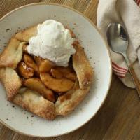 Apple-Huckleberry Open Face Pie · Wild huckleberries, cinnamon apples, salted caramel sauce, served warm with a scoop of vanil...