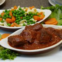 Hungarian Goulash · Cubes of tender, lean, seasoned beef simmered with peas and carrots and served on a bed of n...