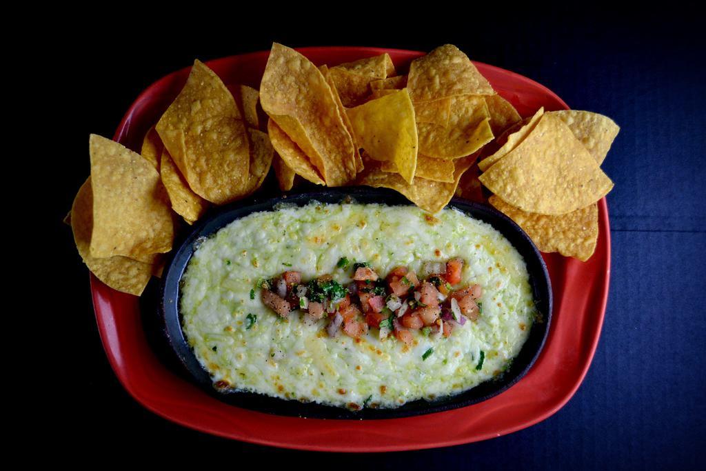 Azteca Queso Dip Dinner · Dip into a warm blend of selected cheeses, spinach and chiles. All baked together and served with fresh tortilla chips.