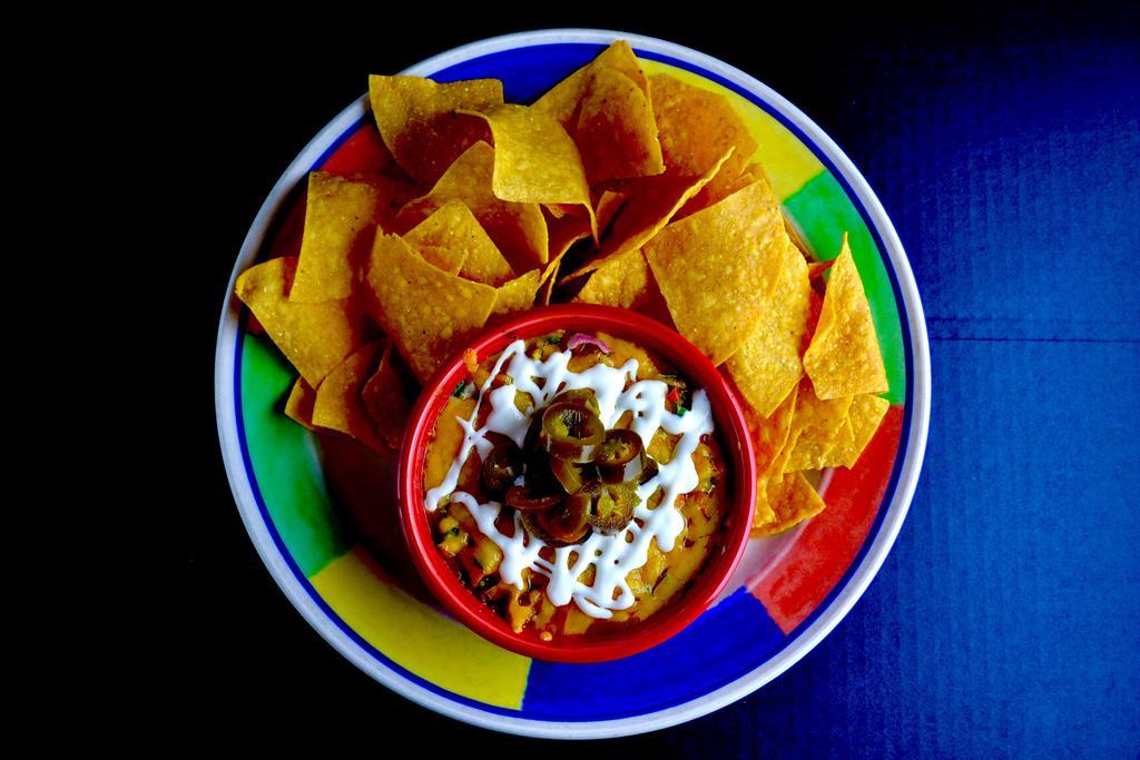 Layered Bean Dip Dinner · Refried beans, enchilada sauce, Jack cheese, Cheddar cheese, guacamole and pico de gallo. Topped with jalapenos.