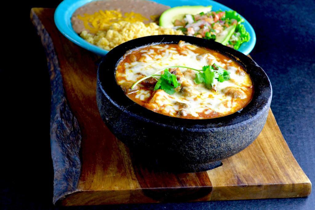 Molcajete Dinner · A Mexican style stew with choice of meat, sauteed in a mildly spicy sauce with mushroom, onions and tomatoes. Topped with melted Jack cheese and garnished with a sliced avocado.