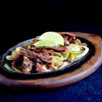 Steak Fajitas Dinner · Steak fajitas are served sizzling hot over a bed of sauteed onions and green peppers with ri...