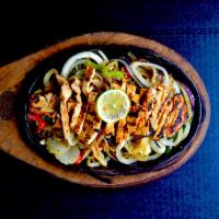 Chicken Fajitas Dinner · Chicken fajitas are served sizzling hot over a bed of sauteed onions and green peppers with ...