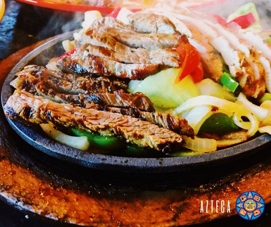 Fajita Sampler Dinner · A combination of steak, chicken and shrimp, served sizzling hot over a bed of sauteed onions and green peppers with rice, beans, pico de gallo, sour cream, guacamole, Cheddar cheese. Side substitution available.