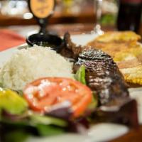 Baby Churrasco · Grilled steak with rice, salad, green plantains, and chimichurri sauce.
