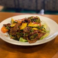 11. Yum Num Tuk · Sliced charbroil beef salad with onions, tomatoes, lettuce, chili and lime dressing. Mild.