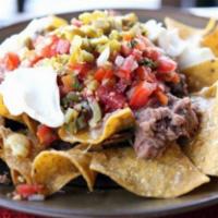 Super Nachos · Meat, cheese, beans and jalapeno peppers.