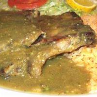 Chuletas de Puerco · Juicy cut pork chops marinated with Mexican spices and tomatillo sauce, served with rice, re...