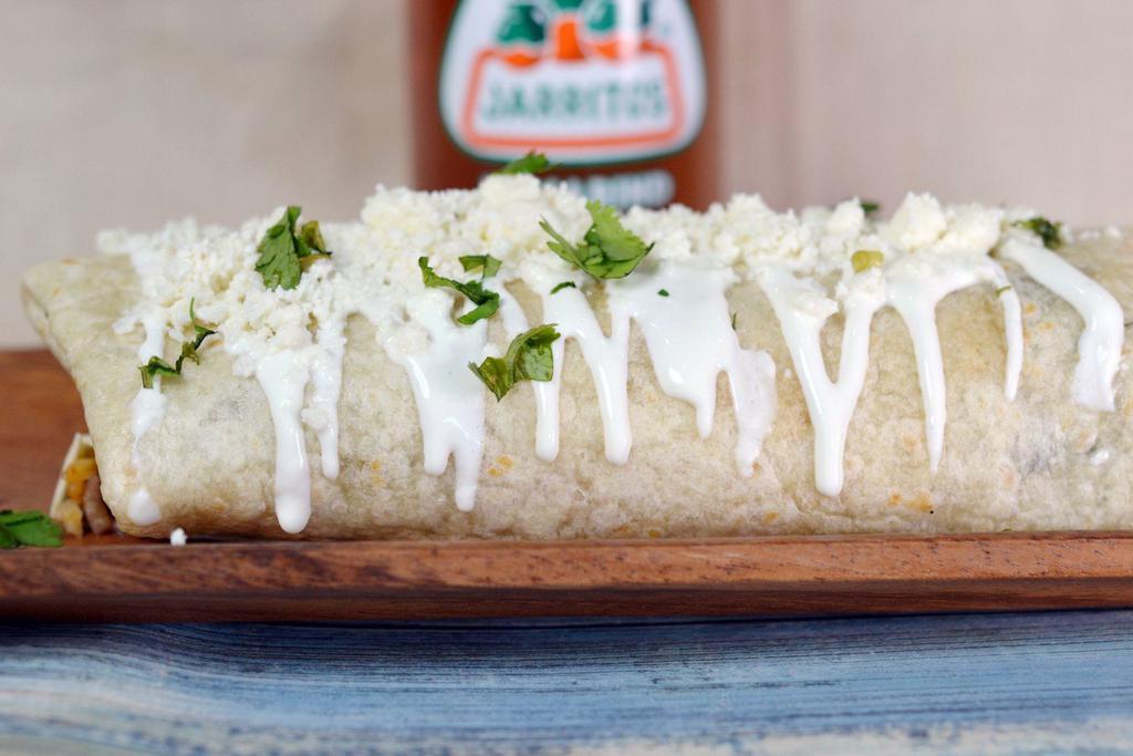 Burrito · Flour tortilla stuffed with choice of filling, rice, beans, onion, tomato, cilantro and topped with crema,  queso fresco