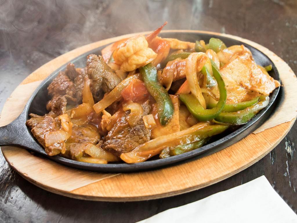 Sizzling Fajitas · Sauteed with onions, bell peppers and tomatoes served on sizzling plate with rice, beans with  flour or corn tortillas.