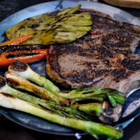 Bistec Estrellita · Grilled rib eye steak with cactus pads, bulb onions and jalapenos