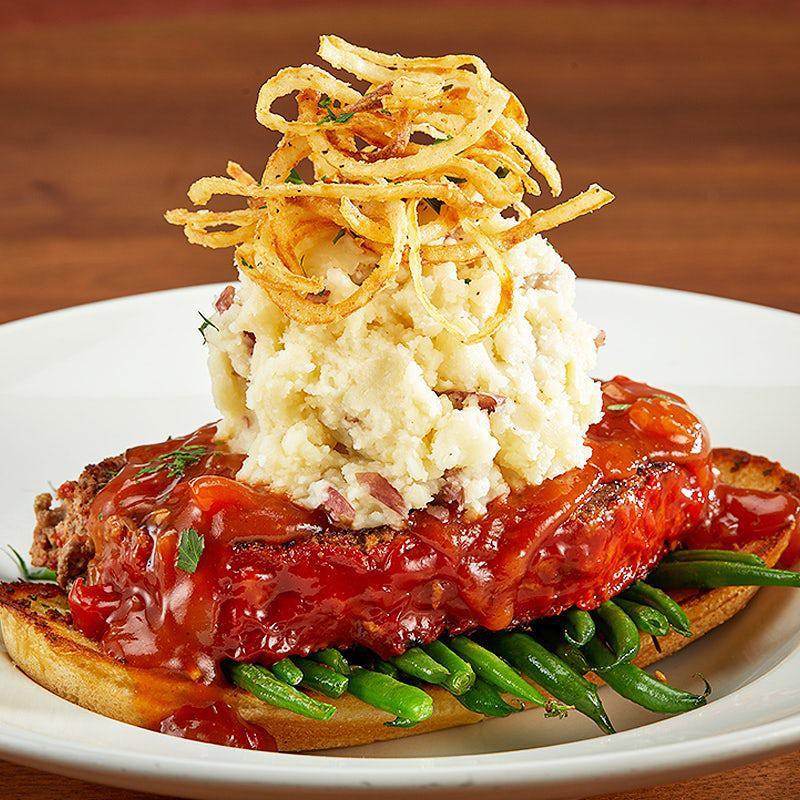 Granite City Meatloaf · This classic appeared on our first menu in 1999! Hand-made meatloaf layered with garlic mashed potatoes, petite green beans, garlic toasted baguette, our famous savory bourbon onion sauce and topped with crispy onion strings.