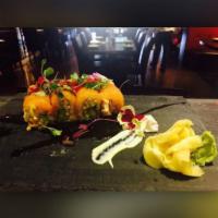 Mango Tango Roll · Spicy king crab and avocado inside topped with fresh salmon, mango and caviar in chef's spec...