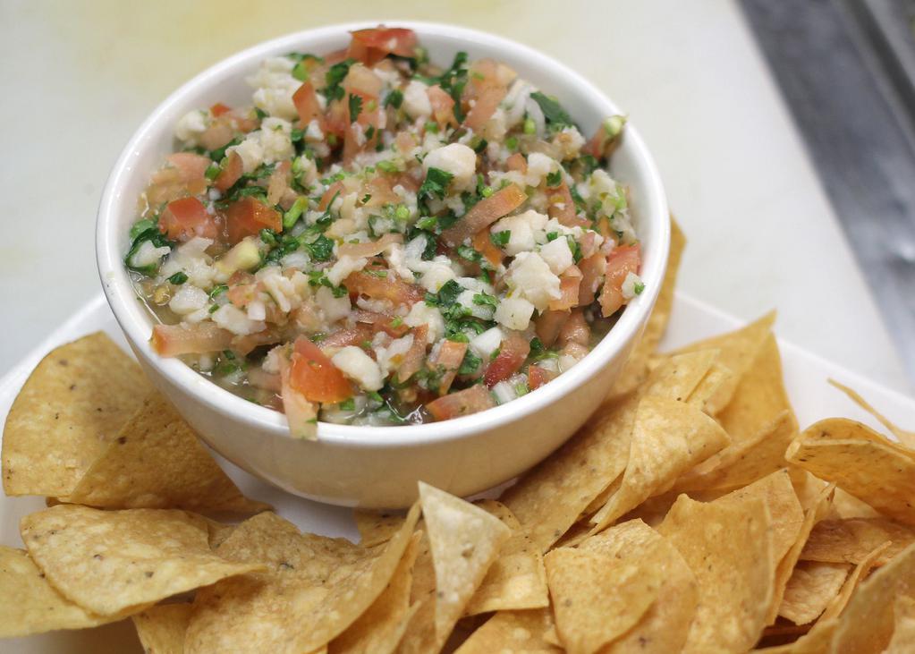 Ceviche of White Fish · Marinated in lime juice with tomato, red onion and cilantro. Served with tortilla chips.