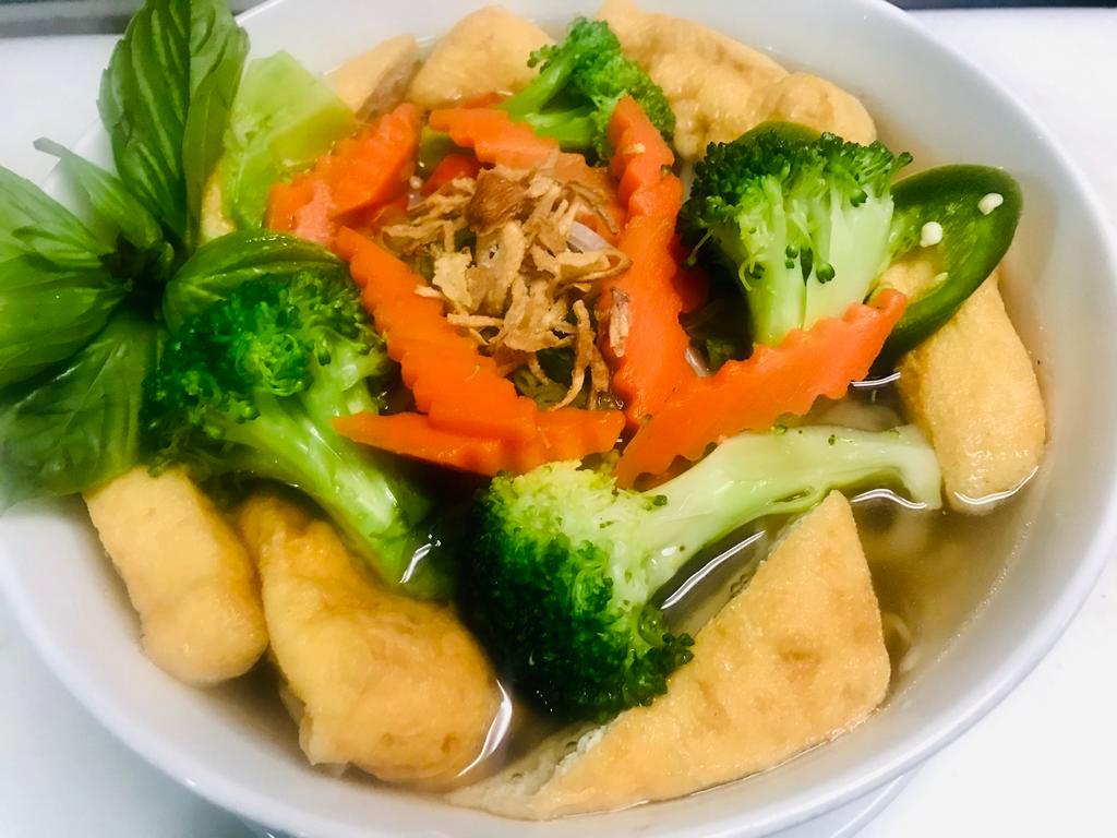 P9. Pho Chay · Vegan pho. Pho with vegan broth, rice noodles, tofu and mixed veggies. Includes broth, flat rice noodles, garnished with mixed onions, cilantro and served with bean sprout, basil, lime wedge and slices of jalapenos on the side. Gluten free.