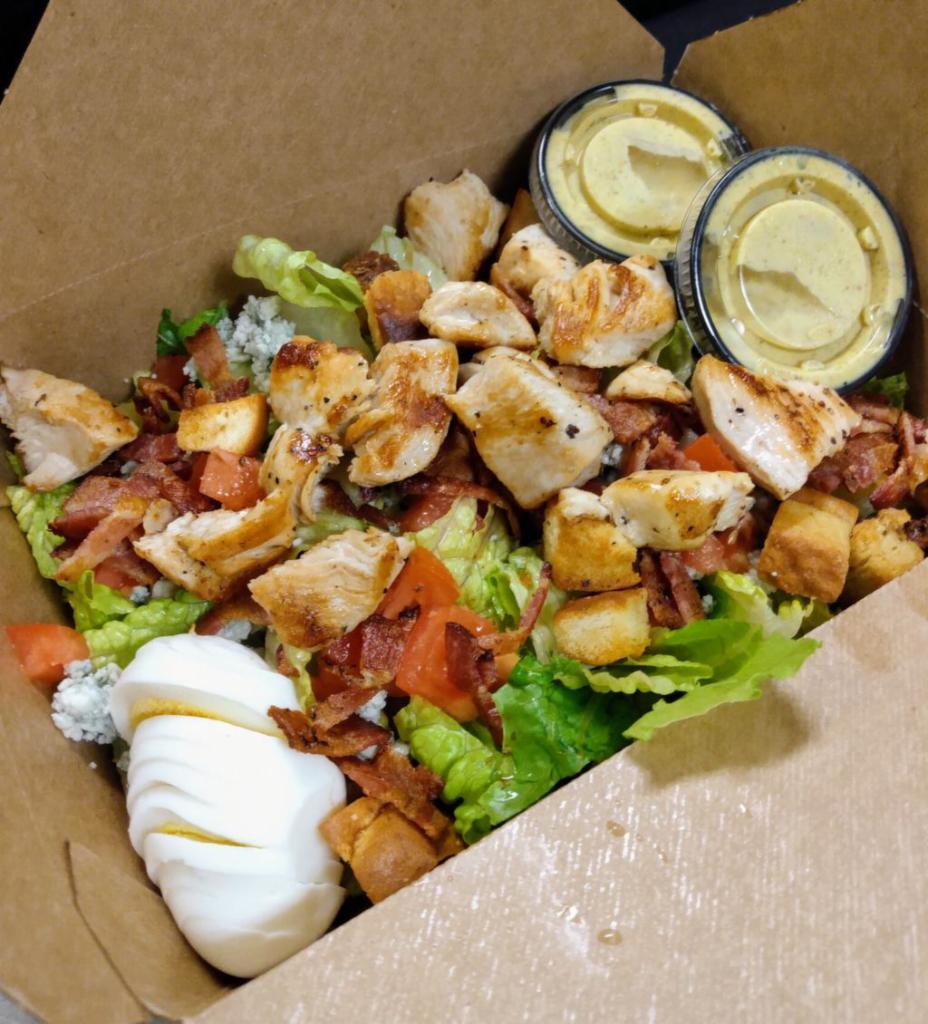 Chicken Cobb Salad · Grilled chopped chicken breast, bacon bits, bleu cheese crumbles, tomatoes, and a hardboiled egg. Choice of dressing. Served with fresh chopped romaine and our house-made croutons.