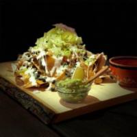 Nachos · Homemade tortilla chips layered with black beans, lettuce, and pico de gallo. Smothered with...
