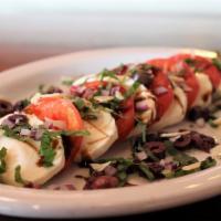 Caprese Salad · Roma tomatoes, fresh mozzarella, basil, red onion, Kalamata olives, Balsamic glaze, olive oi...