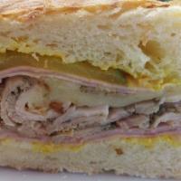 Cubano Sandwich · Ham, homemade porchetta, Swiss cheese, pickles, mustard on homemade ciabatta bread.