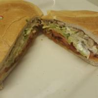 Milanesa de Res Torta · Breaded beef. With a refried bean base, lettuce, tomato, onion, avocado, and sour cream.