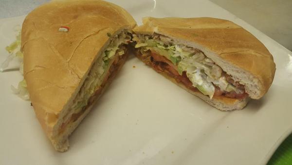 Milanesa de Res Torta · Breaded beef. With a refried bean base, lettuce, tomato, onion, avocado, and sour cream.