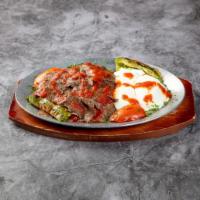 Iskender · Layers of lamb gyro served over toasted bread and tomato sauce.