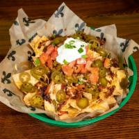 The Supreme Ruler Nachos · Served with warm queso cheese and topped off with onions, tomatoes, jalapeno peppers and you...