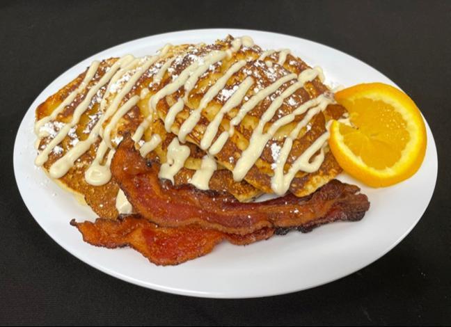Cinnamon Swirl Pancakes · Our classic buttermilk pancakes filled with cinnamon and sugar finished with vanilla cream cheese icing. Served with applewood-smoked bacon.