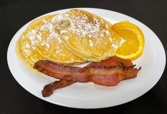 Classic Buttermilk Pancakes · Our classic buttermilk pancakes topped with a scoop of cane syrup butter. Served with applewood-smoked bacon.