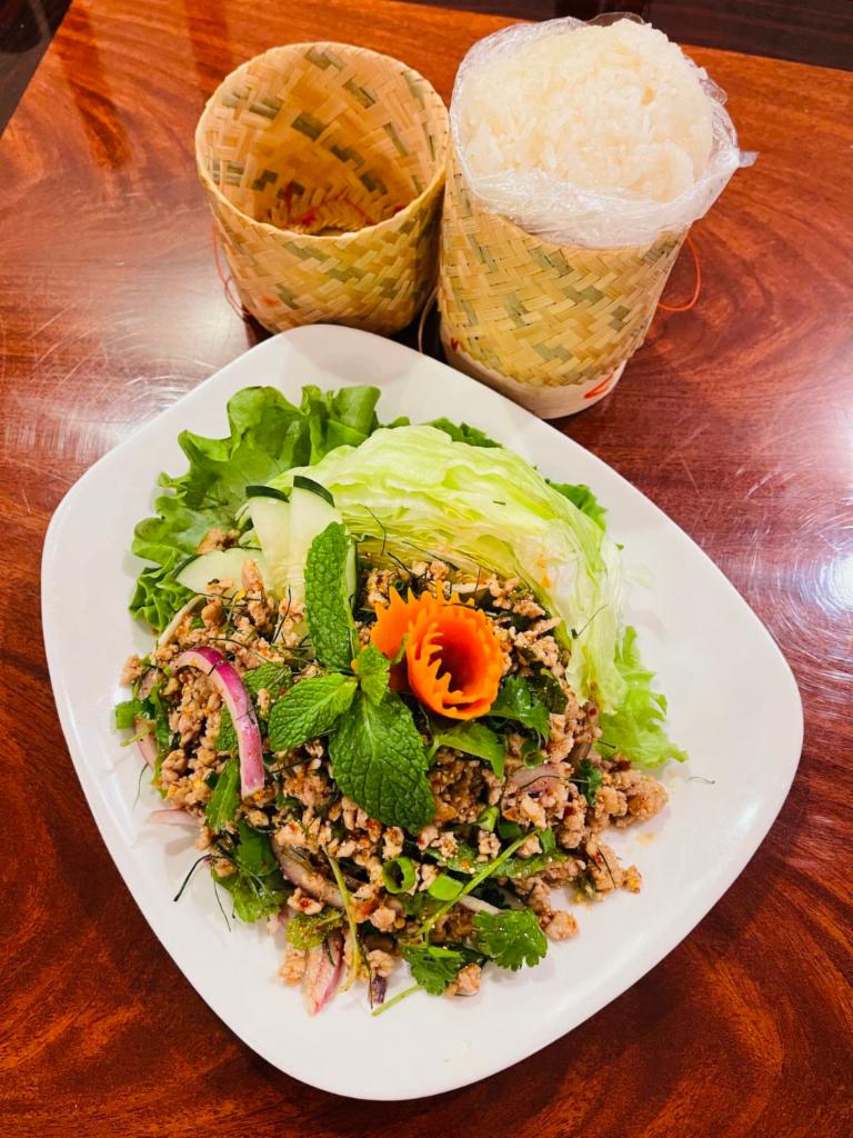 Larb Moo with Sticky Rice Salad · Minced chicken, red onion tossed in spicy lime dressing, roasted rice powder, green onion, mint, and cilantro.  Choose a spice level.