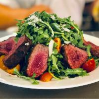 Steak and Arugula Salad · Grilled 10 oz. grass fed tender steak “tagliata” served on a bed of arugula, heirloom tomato...