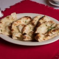 Garlic Naan · Naan bread baked in ‘Tondoori Clay Oven’ topped with fresh minced garlic and cilantro.