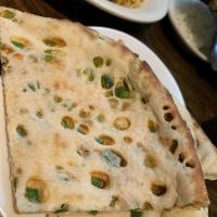 Chili Naan · Naan bread stuffed with freshly chopped green chili, shredded cheese, and chopped onion, wit...