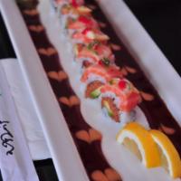 Pink Dragon Roll · Spicy tuna and avocado inside and topped with salmon and lettuce with tobiko and scallion.