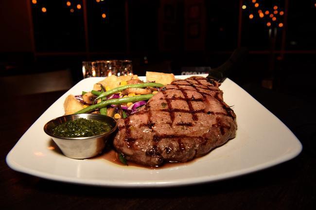 Ozzy's Ribeye · Certified Angus Beef ribeye, sautèed green beans, red cabbage, corn, yuca and chimichrri sauce