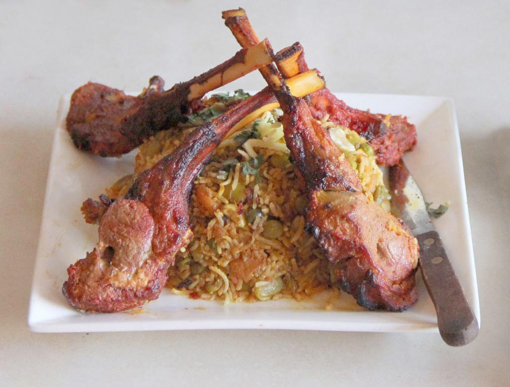 Lamb Chops · Succulent pieces of lamb chops marinated in spices then broiled on skewer over charcoal in the tandoor, served with vegetable biryani.