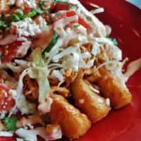 Salvador Fries · Yuca fries with shredded chicken sauteed with tomato and onion, topped with cabbage, pico de...