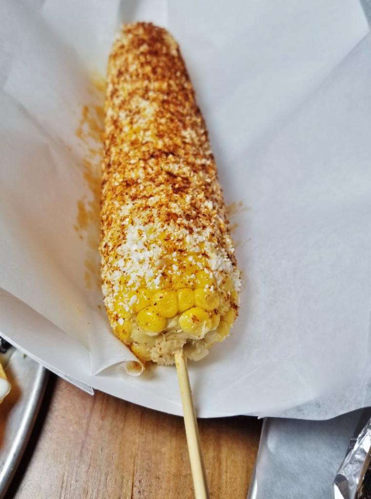 Elote Loco · Corn on the cob lightly coated with mayo and covered with Cotija cheese and dusted with chili powder.