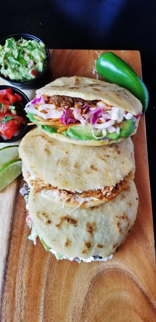 Arepas Tradicional · Venezuelan style white maize cake filled with shredded chicken, diced tomato, onion, cheese and Rosado sauce.