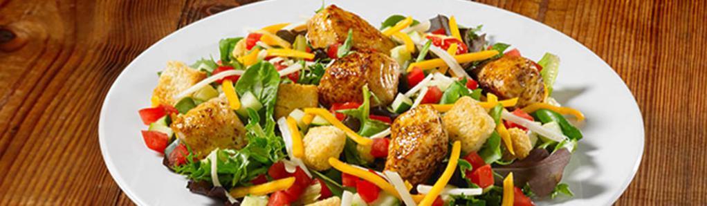 Chicken Garden Salad · Spring mix greens piled with diced tomatoes, crisp cucumbers, cheddar cheese, Monterey Jack cheese, and croutons, and your choice of salad dressing. Topped with grilled or fried chicken.