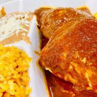Pollo en Mole · Two chicken pieces topped with mole sauce (Rice and beans).