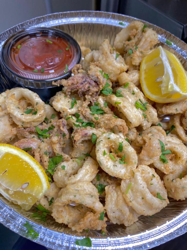 Calamares Fritos · Calamari tossed in cornmeal deep-fried to golden crispy with parsley and tomato sauce on the side.
