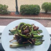Dactiles con Tocino · Dates wrapped in smoked applewood bacon cooked to crunchy over a bed of grilled scallions dr...