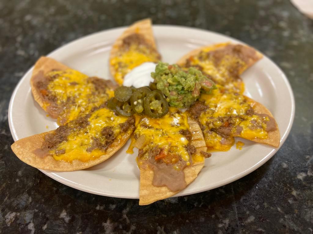 Nachos · Tortilla chips topped with your choice of meat, refried beans, cheddar cheese jalapenos, sour cream and guacamole. 